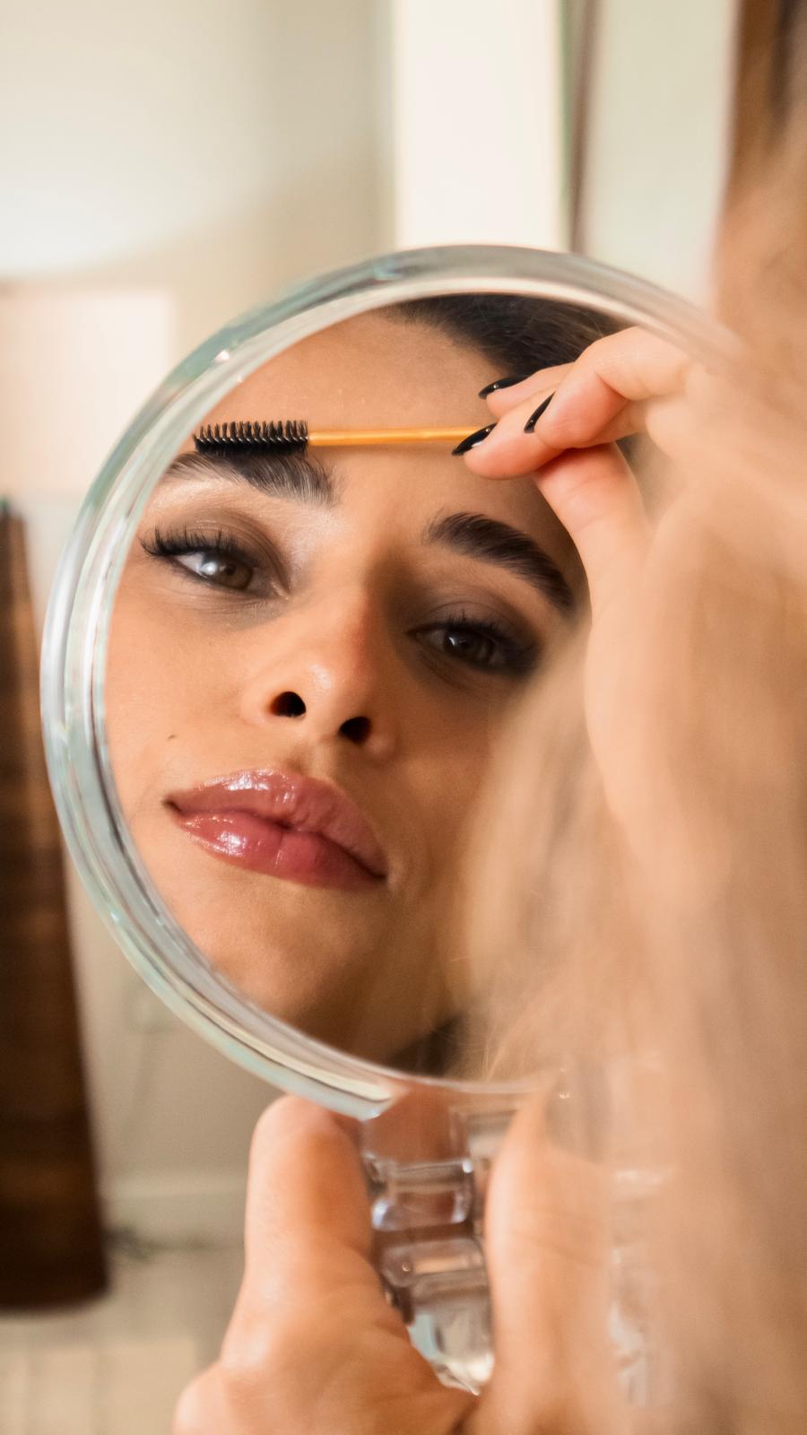 Client checking her freshly shaped brows in a hand mirror at Studio Di Maria